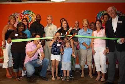 Owner Nikki Hawks Jones, assisted by her children, cuts the ribbon.