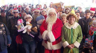 Jim Lovell (Santa) and Bill Helton (Buddy the Elf) lead a contingent of approximately 250 bikers bearing gifts through the doors of the Conway Regional Women’s Center.