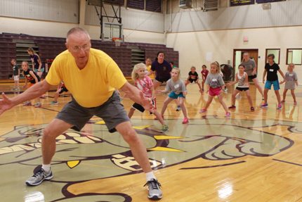 Coach Paul Noesser demonstrates a defensive stance.